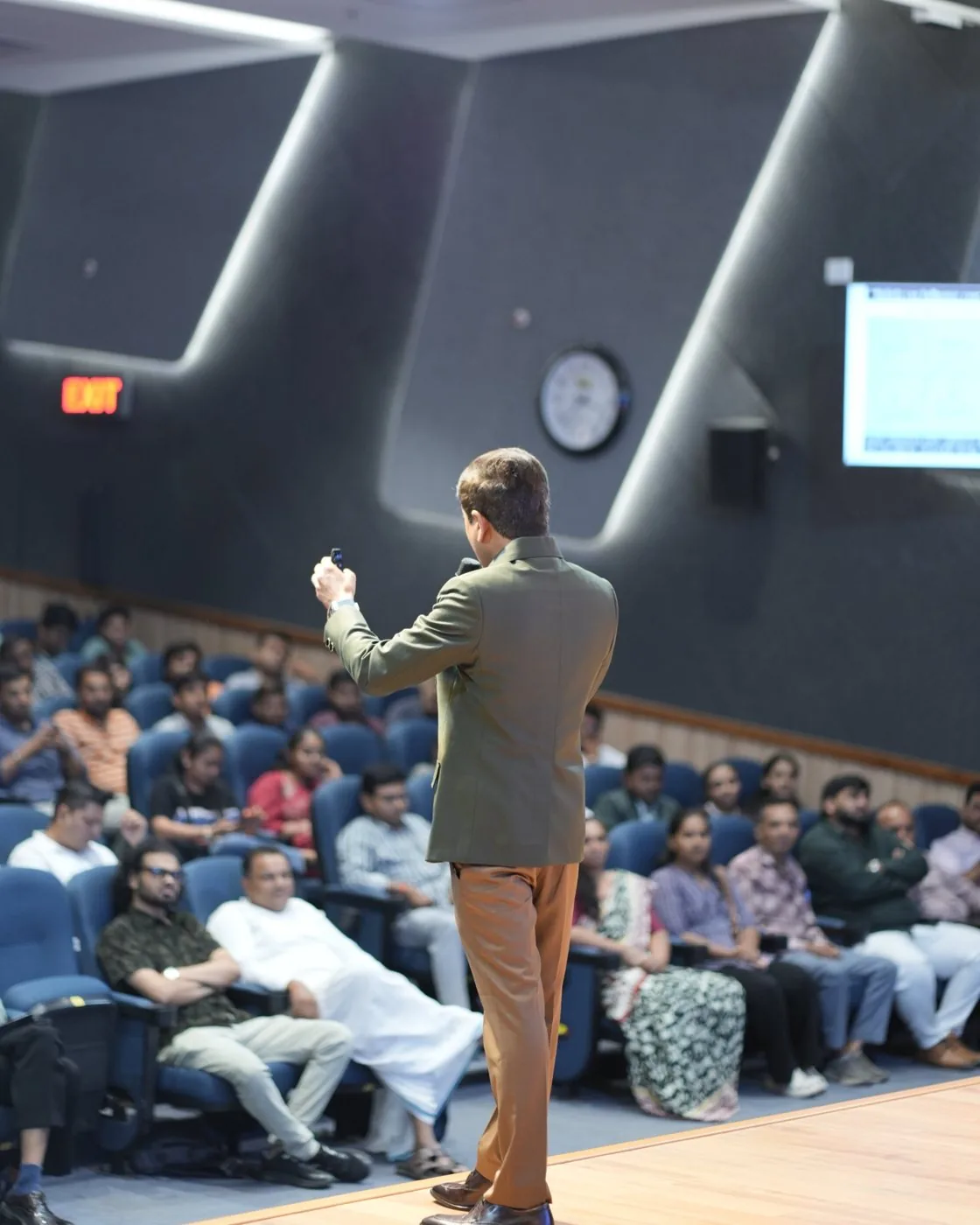 Nilesh Mataria speaking to a full auditorium