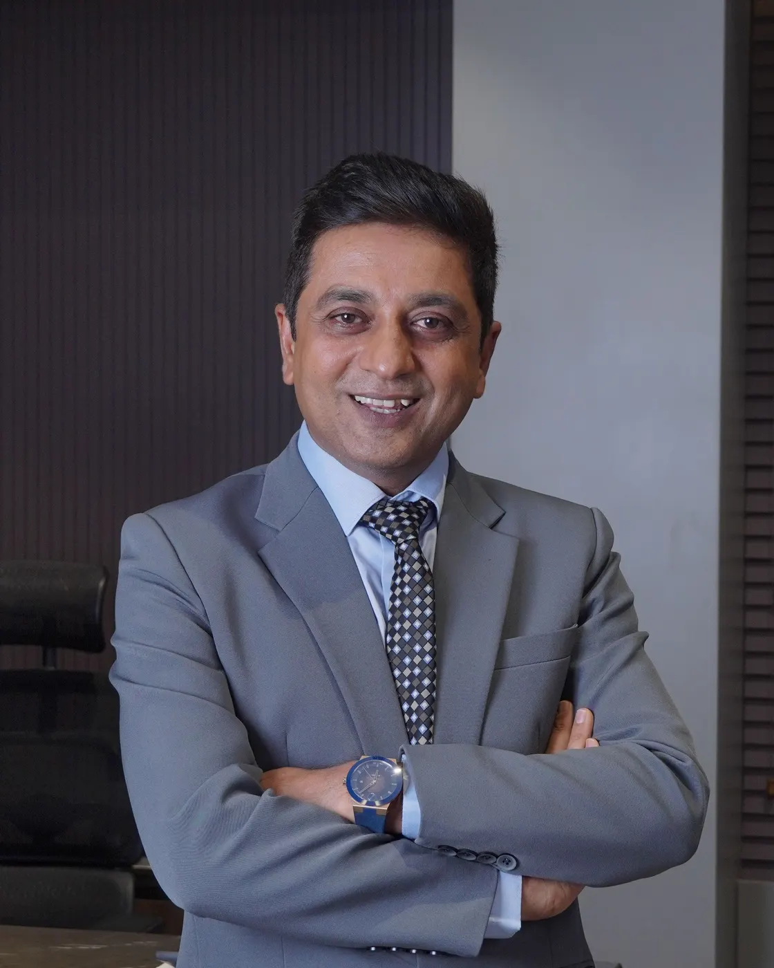 Nilesh Mataria in his office, arms crossed and smiling