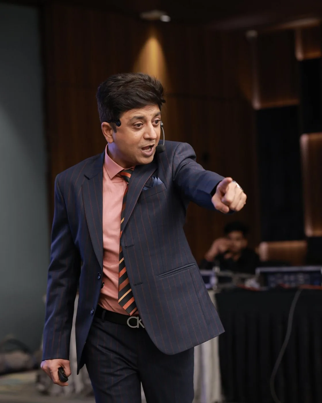 Nilesh Mataria on stage, pointing at the audience